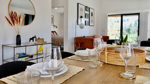 A dining area with a wooden table set for a meal, a mirror, and framed pictures on the wall. - Completely Remodeled, Full Tennis Privileges, ALWAYS Clean at Palm Valley CC!!   (Palm Desert)