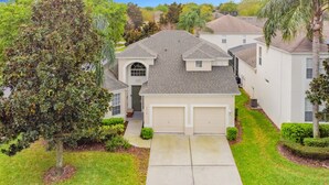 A suburban house with a garage, a driveway, and a well-maintained lawn. - Star Wars Villa - 10 Mins to Disney (Kissimmee)