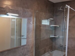 A modern bathroom with a glass-enclosed shower, a large mirror, and a built-in shelf. - La Perla Benalmadena Apartment 1st Line Apartment (BENALMADENA COSTA)