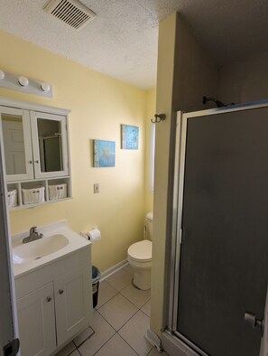 A bathroom with a white vanity, a toilet, and a shower enclosure. - 2 bedroom condo close to the boardwalk and attractions such as Jolly Roger (Ocean City)