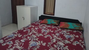Un dormitorio con cama, armario y ventana con cortinas.