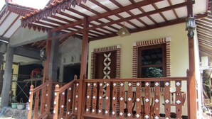 Un balcón de madera tradicional con barandillas intrincadas y un tejado de tejas.