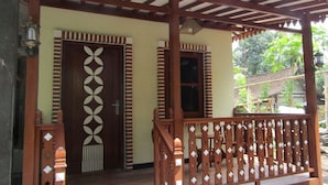 Un porche de madera con una puerta decorativa y un banco.