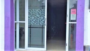 A building entrance with a sliding glass door and a sign on the right.