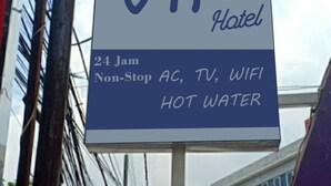 Cartel de un Hotel VIP que ofrece servicios las 24 horas, incluyendo aire acondicionado, TV, WiFi y agua caliente.