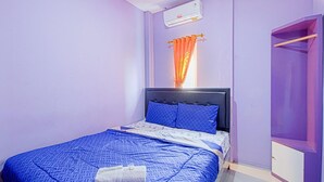 Un dormitorio con cama, armario y equipo de aire acondicionado.