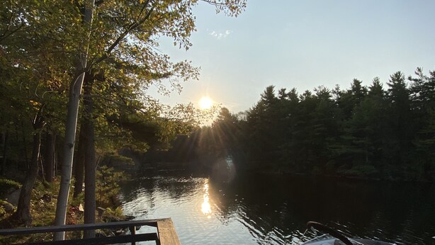 A wooden dock with a boat moored at the end, surrounded by trees and a calm body of water. - WestWind Georgian Bay Muskoka Cottage Retreat Private Access (Sleeps Max 8) (MacTier)