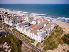An aerial view of a coastal residential area with multi-story buildings, a beach, and a road. - TEQUILA SUNRISE.. LUXURY Oceanfront in Sandbridge (Virginia Beach)