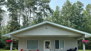 A single-story house with a covered porch, a door, and windows. - Guest House at Parkland Beach, Gull Lake (Ponoka County)