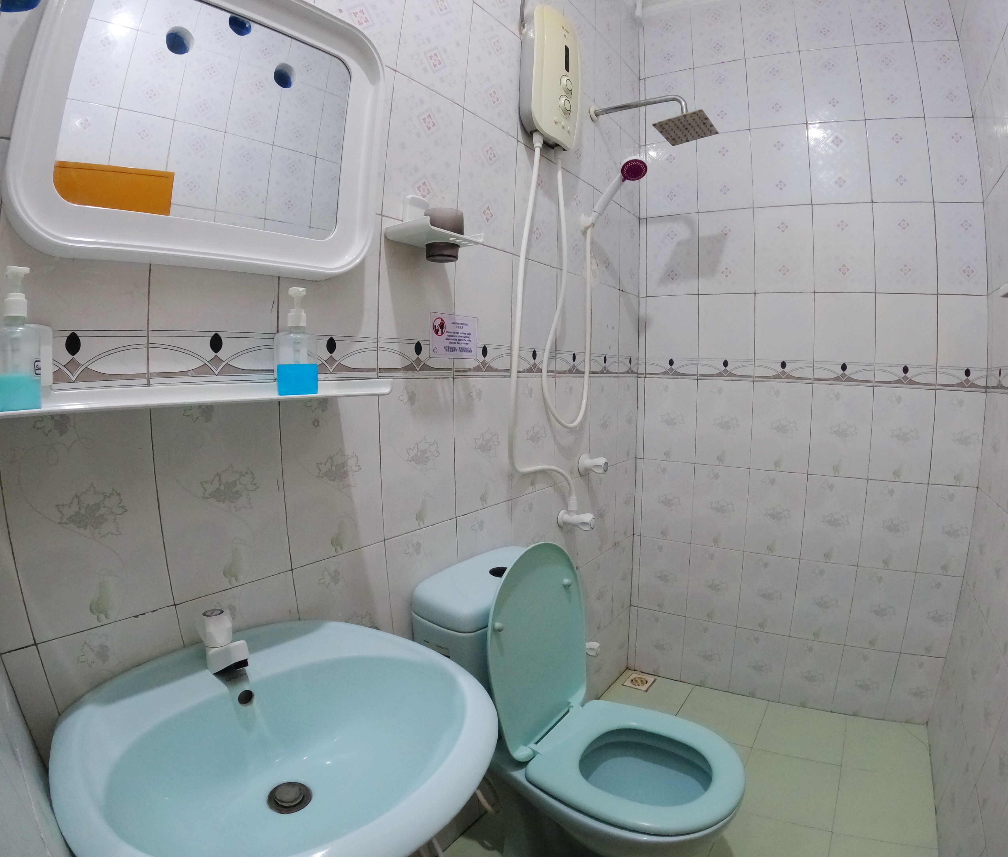 A bathroom with a sink, toilet, and shower.