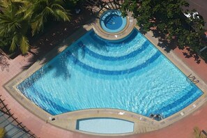 A large, rectangular swimming pool with a central water feature and a surrounding deck area. - Hock Lee Hotel And Residences (Kuching)