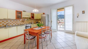 Cocina compacta con comedor, refrigerador y vistas al exterior.