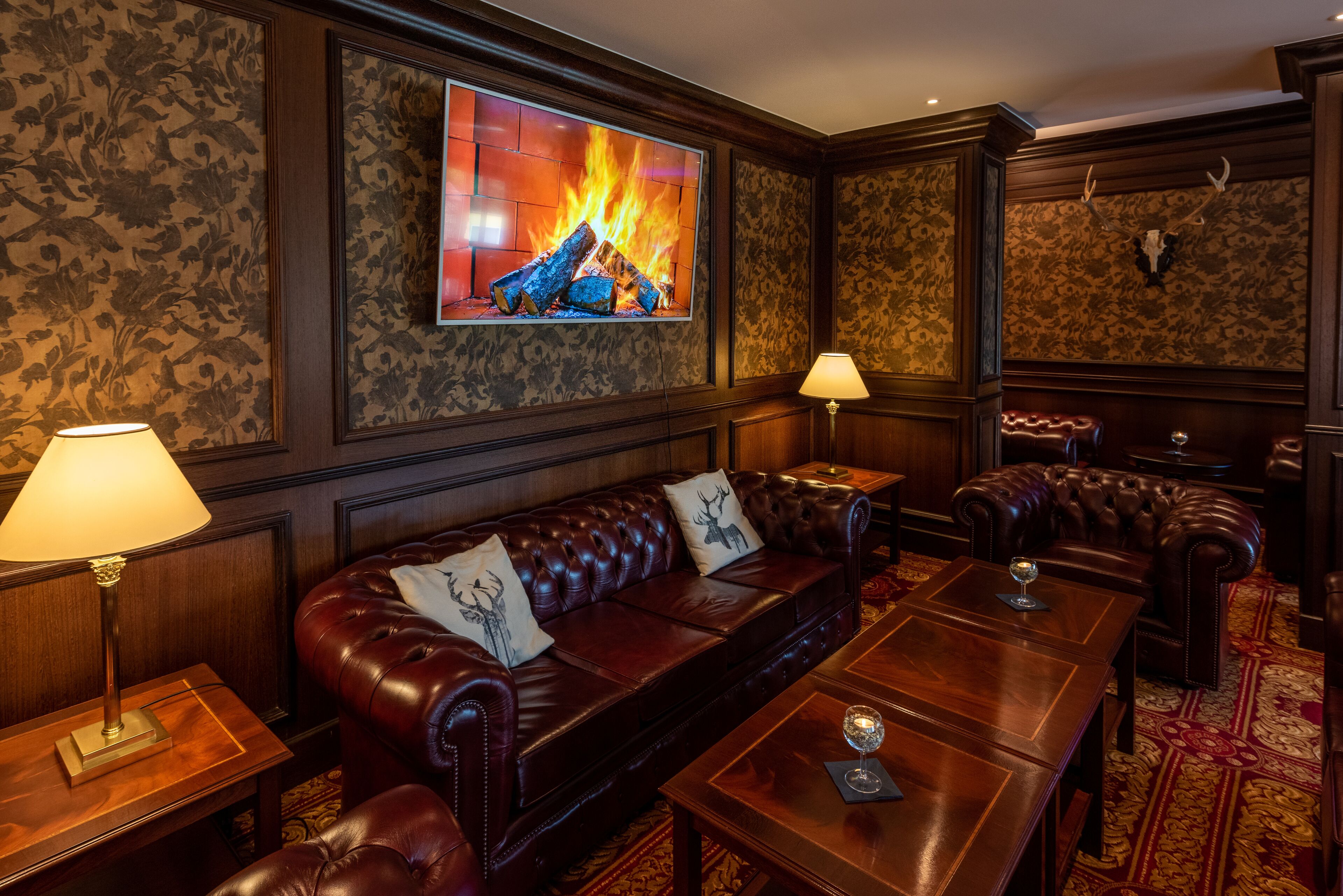 A cozy room with a fireplace, leather sofas, and a wooden coffee table.