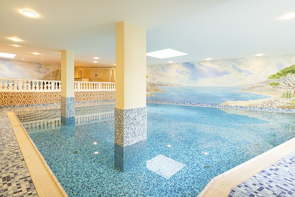 Una piscina techada, sillones reclinables de piscina