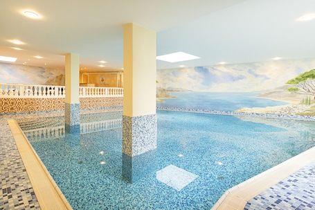 Una piscina techada, sillones reclinables de piscina