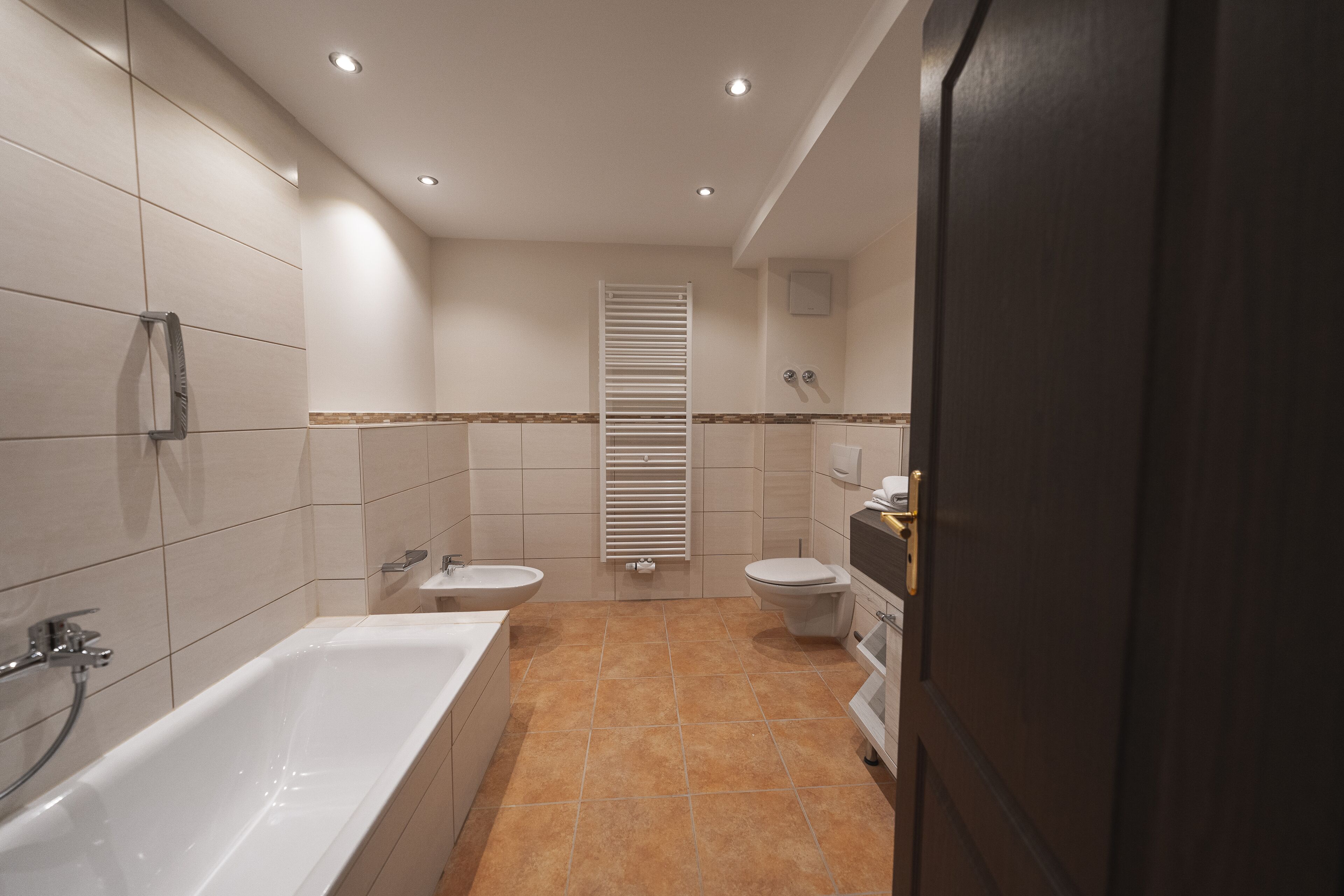 Une salle de bain moderne avec une baignoire, deux lavabos et des toilettes.