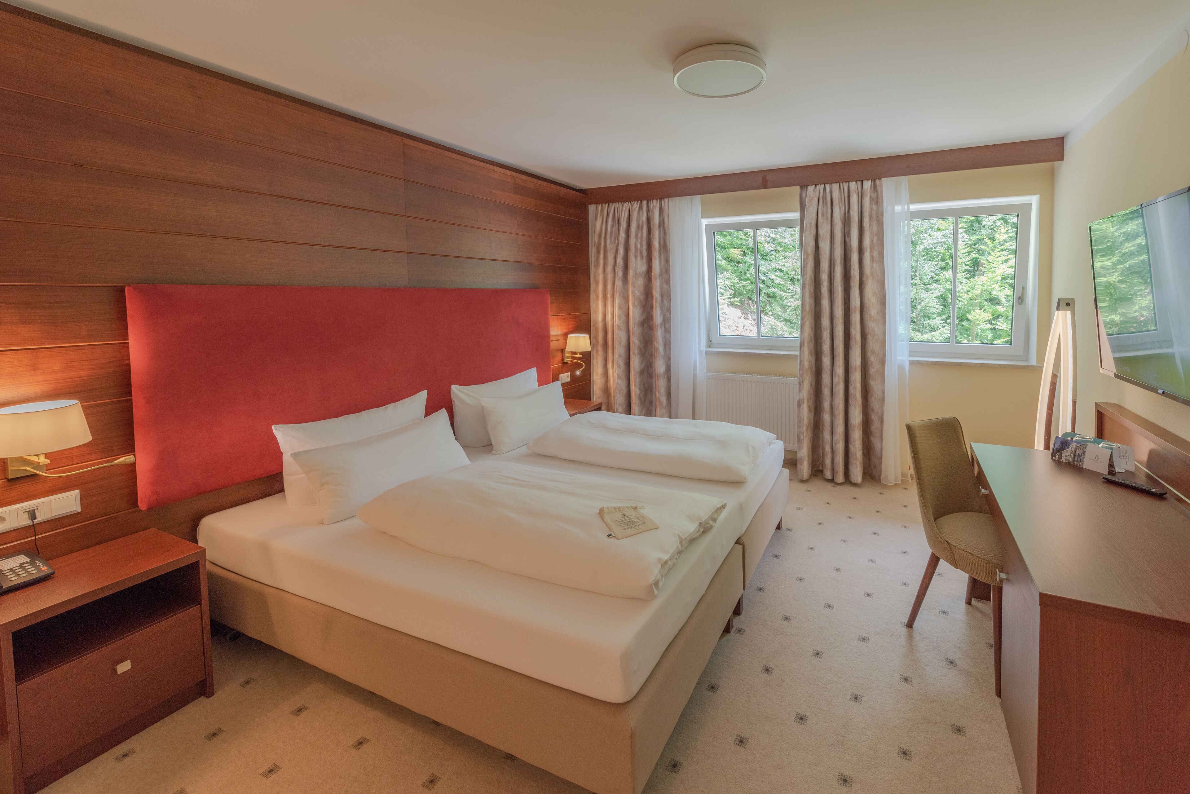 Ein Hotelzimmer mit einem großen Bett, einem Schreibtisch und einem Stuhl.