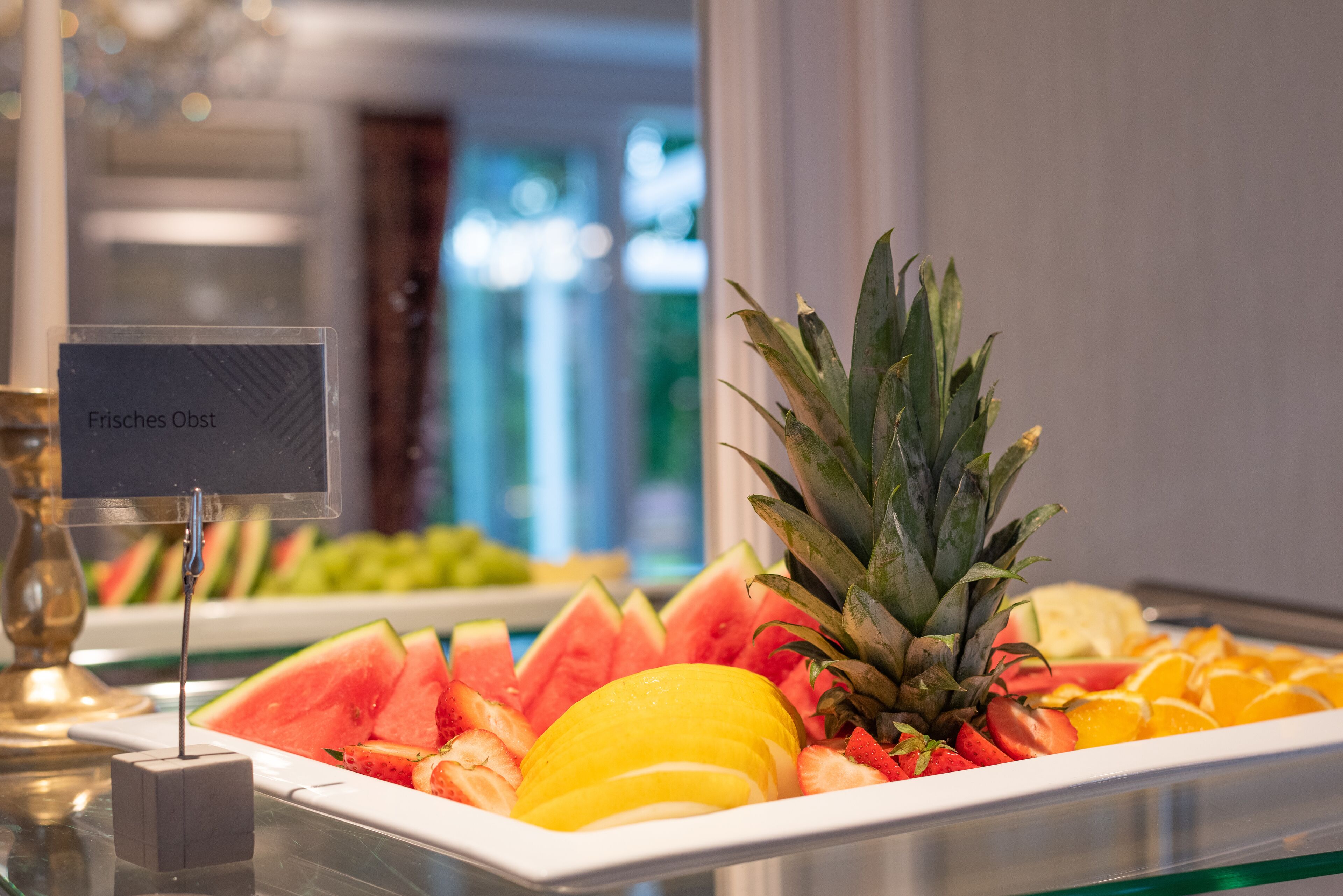 A buffet with a variety of fruits including watermelon, pineapple, and oranges.