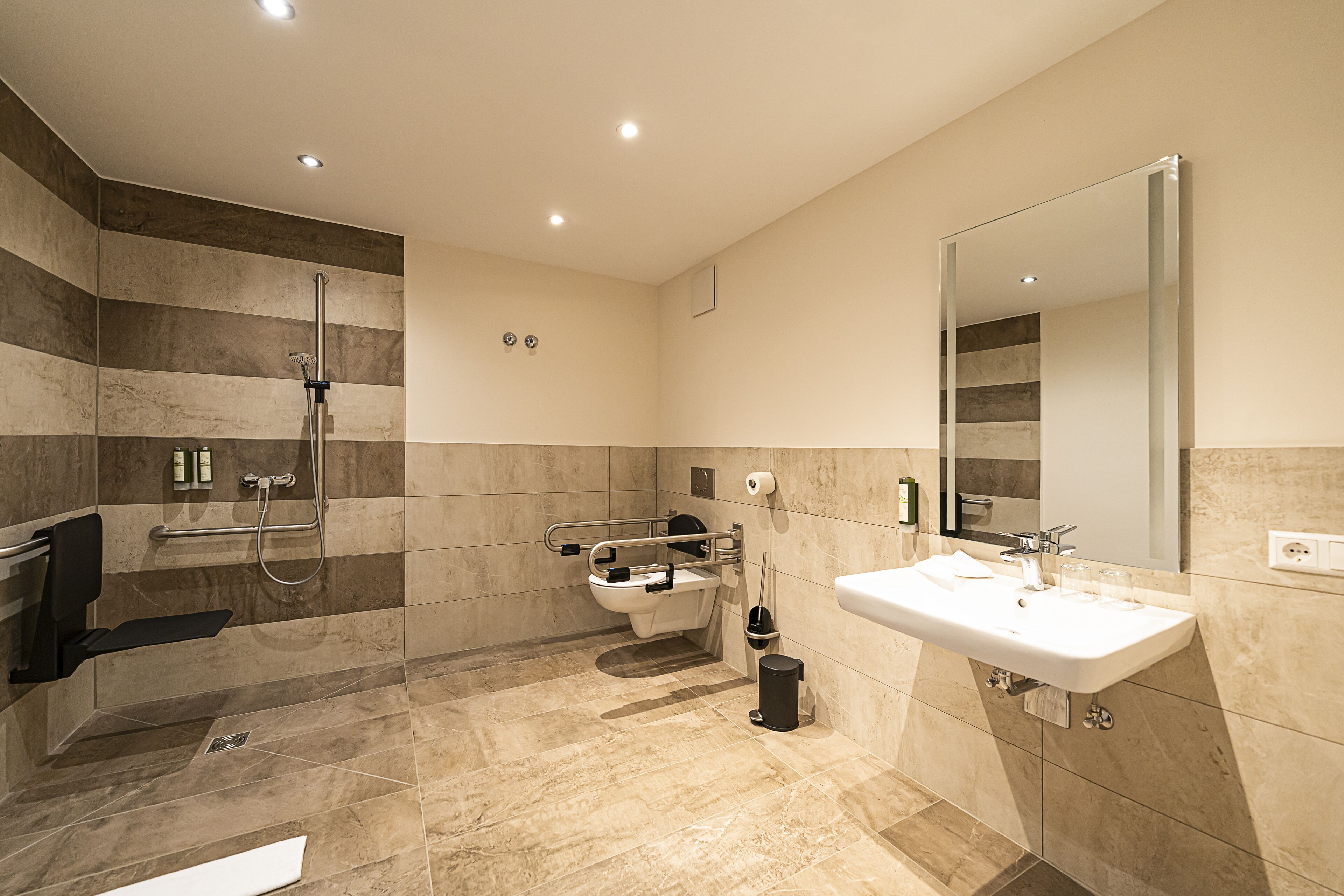 A modern bathroom with a shower, toilet, and sink.