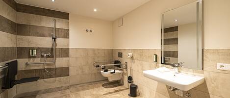 A modern bathroom with a shower, toilet, and sink.