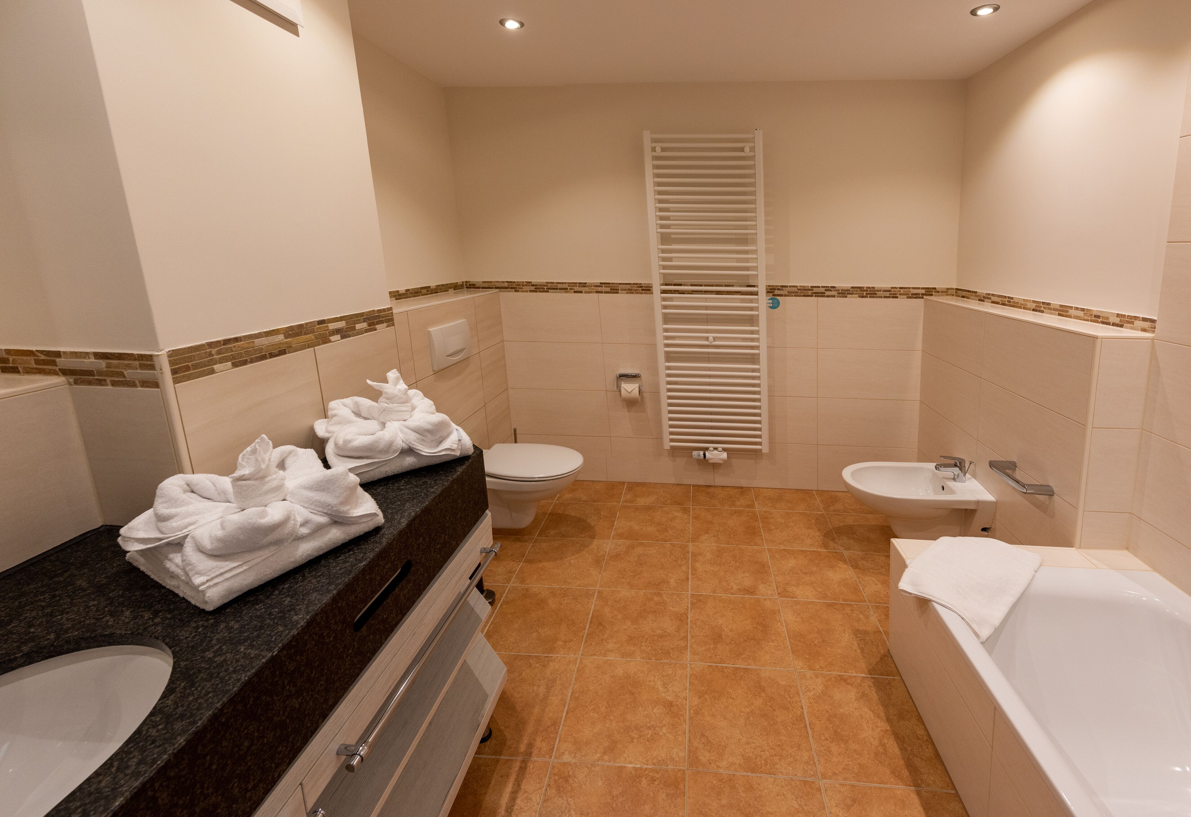 Une salle de bain équipée d’un lavabo, de toilettes, d’une baignoire et d’un porte-serviettes.