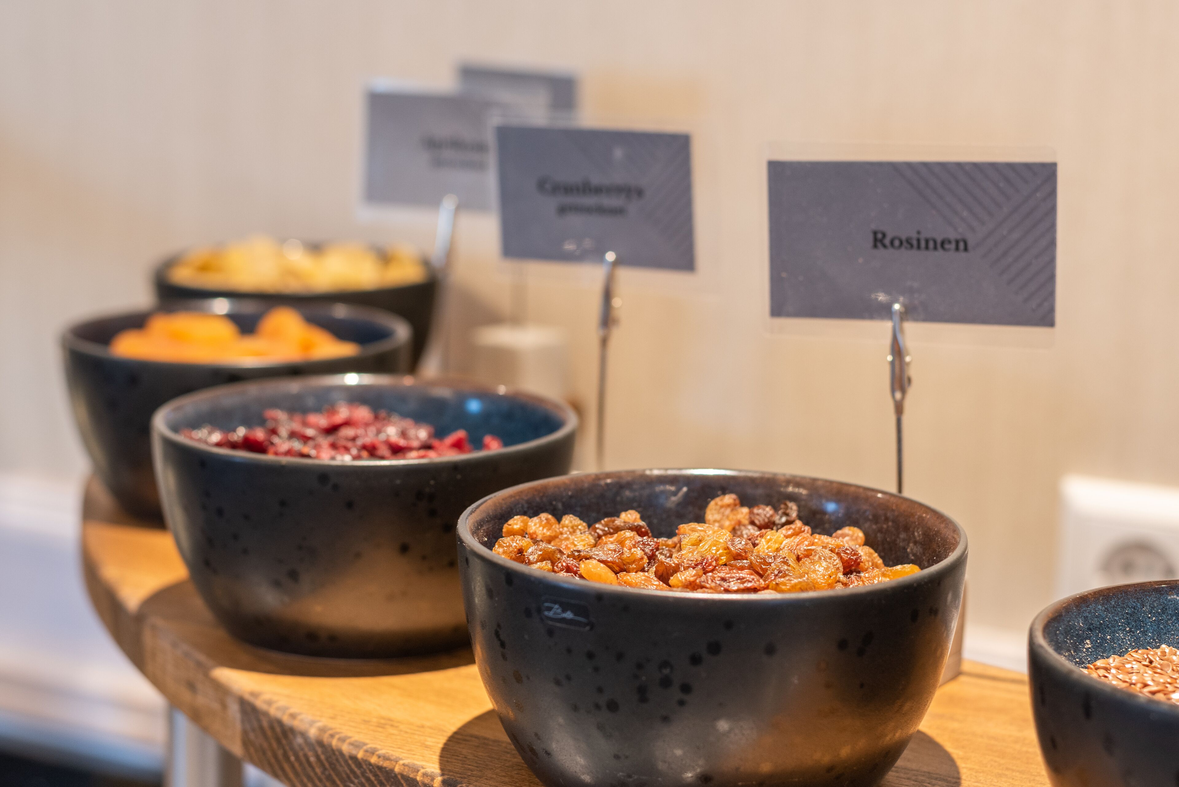 Une sélection de bols contenant différents types d’aliments, chacun étant identifié par une étiquette indiquant son nom.