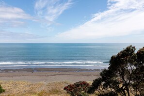 A beach with a clear view of the ocean and distant shoreline.