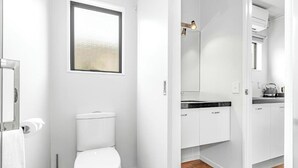 A modern bathroom with a toilet, a bidet, and a shower area. - Auckland Akl Airport Motel (Auckland)