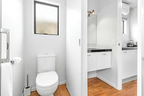 A modern bathroom with a toilet, a bidet, and a shower area. - Auckland Akl Airport Motel (Auckland)