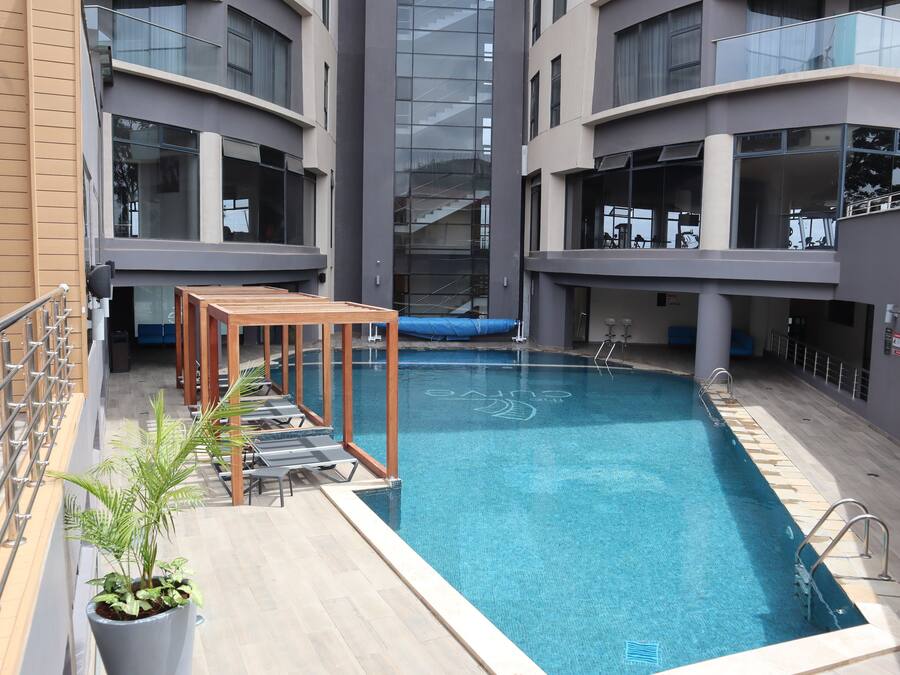 Una piscina al aire libre, sillones reclinables de piscina