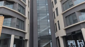 Ein Hochhaus mit modernem architektonischen Design, mit geschwungenen Balkonen und einer zentralen Glasfassade.