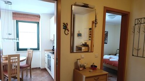 A compact kitchen with a dining area, a small dresser, and a mirror. - Villa Laura 12 - Laura 12 (Kühlungsborn)