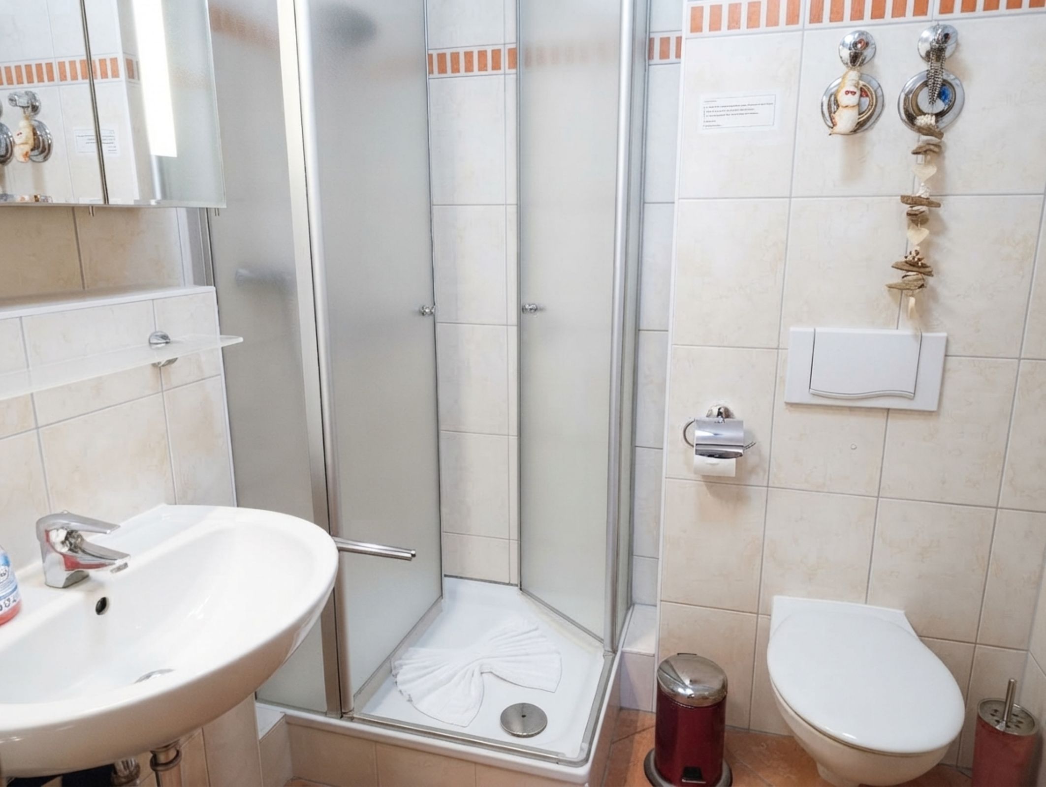 Une salle de bain équipée d’une douche, d’un lavabo, de toilettes et d’un porte-serviettes.