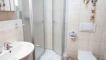Une salle de bain équipée d’une douche, d’un lavabo, de toilettes et d’un porte-serviettes.
