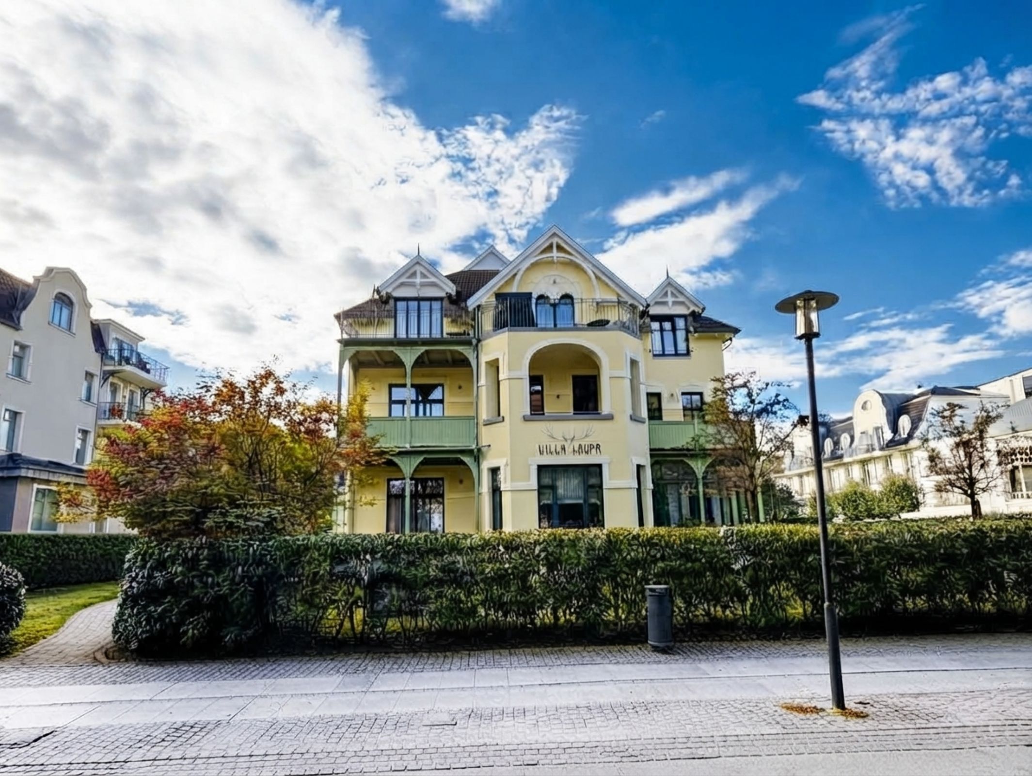 A multi-story building with a central entrance, balconies, and a sign that reads 'Villa Lawra.'