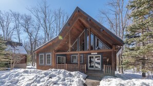 Une cabane en bois dotée d’une grande véranda et d’une pancarte indiquant : « Fisher est absent ».
