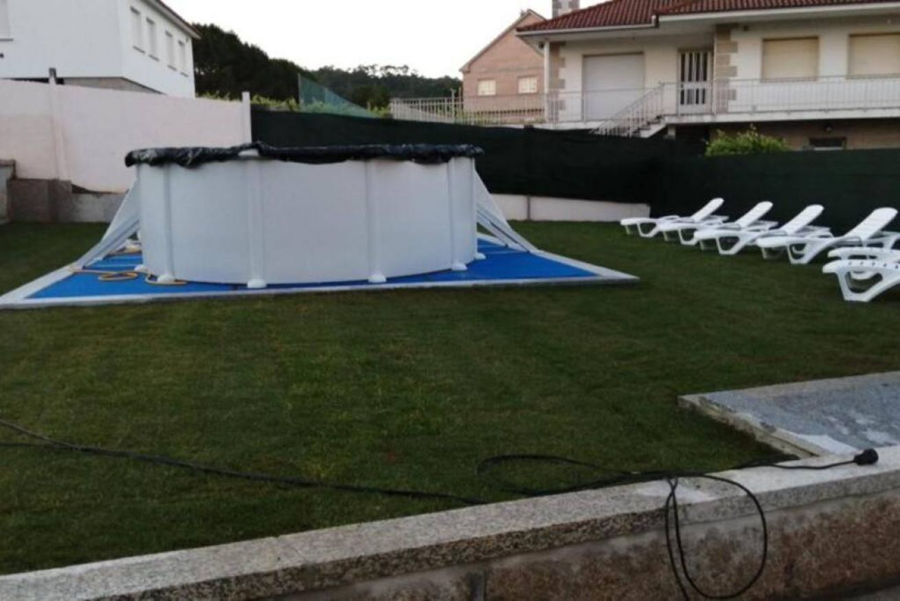 An outdoor swimming pool area with a diving board and lounge chairs.