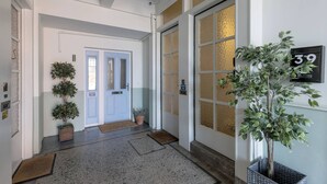 Un couloir avec une porte à deux battants, un pot de fleurs et un panneau indiquant le numéro de la pièce : 39.