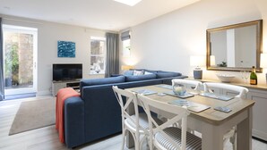 Un salon moderne avec un canapé, une table à manger et un téléviseur.
