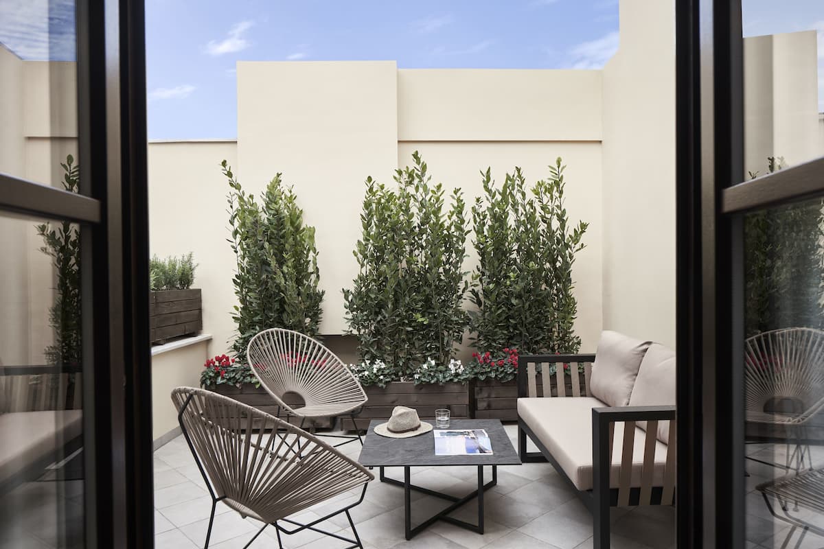 Un patio moderno al aire libre con un sofá, sillas y una mesa.
