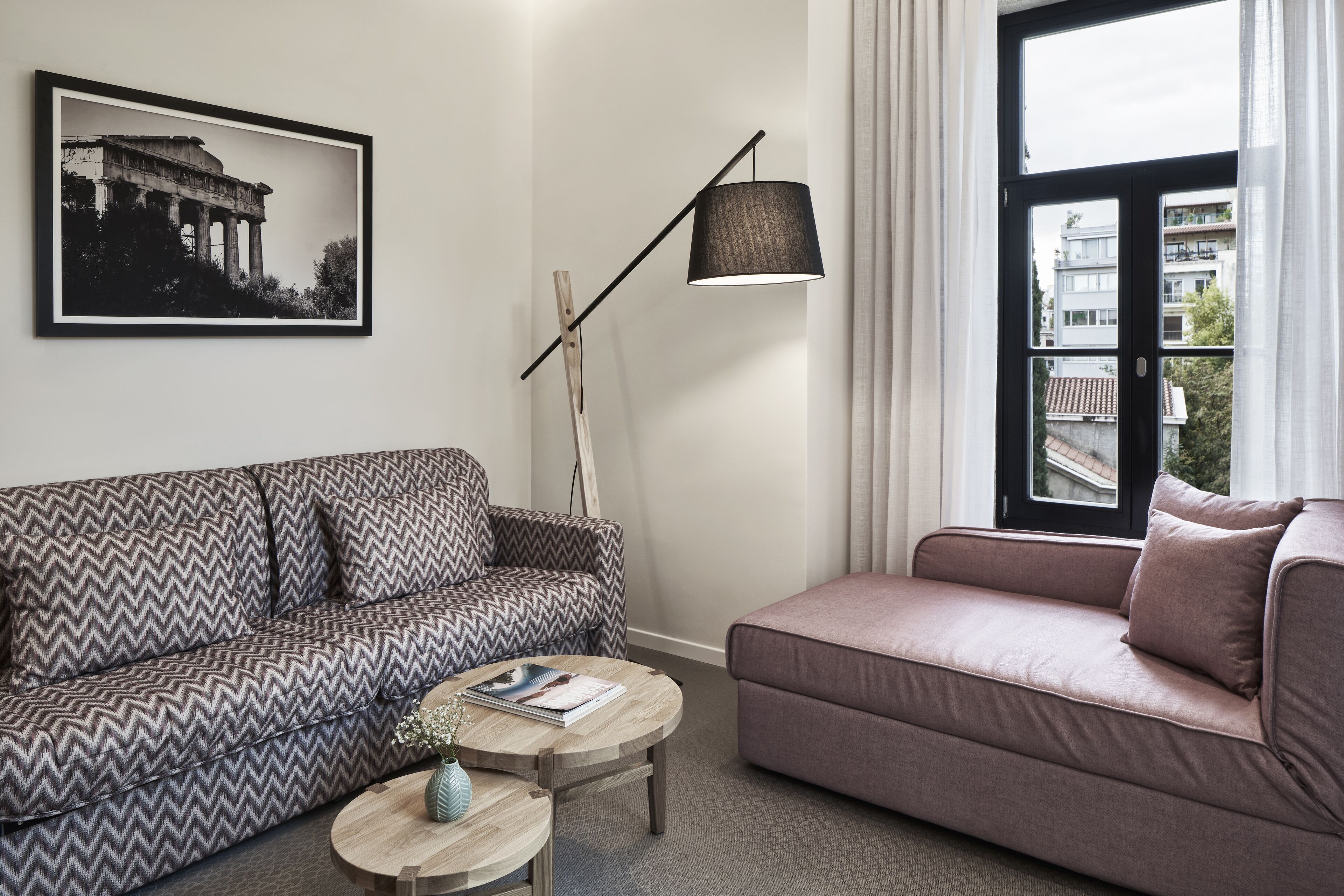 Een moderne woonkamer met twee banken, een vloerlamp en een ronde salontafel.