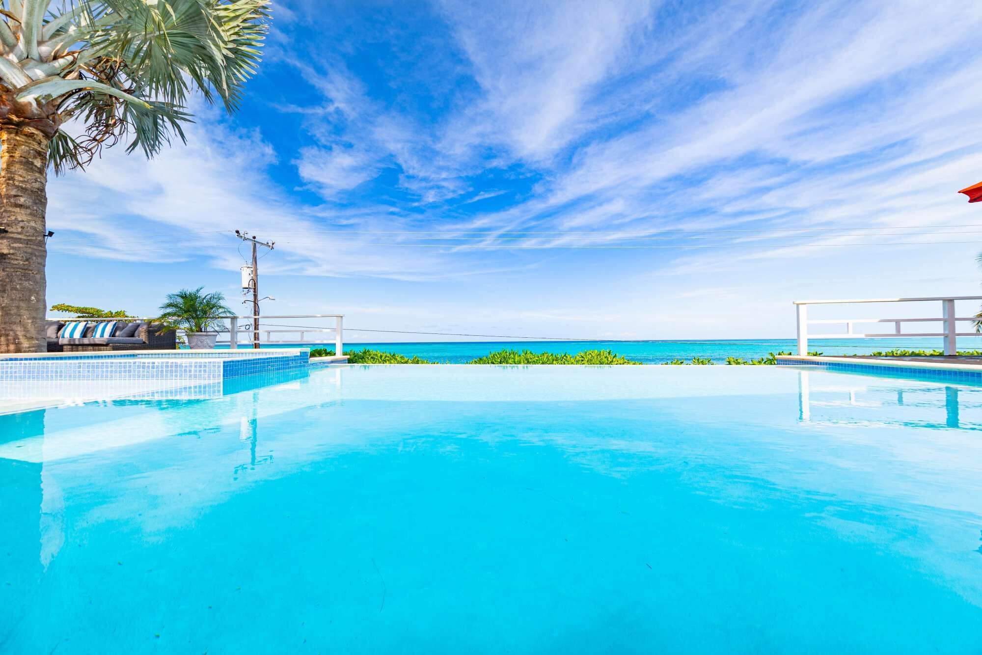 Un cielo azul despejado, una piscina y vistas al océano.