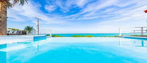Un cielo azul despejado, una piscina y vistas al océano.