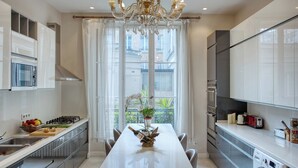 Une cuisine moderne dotée d’un îlot central, d’un four encastré et d’une grande fenêtre offrant une vue dégagée.