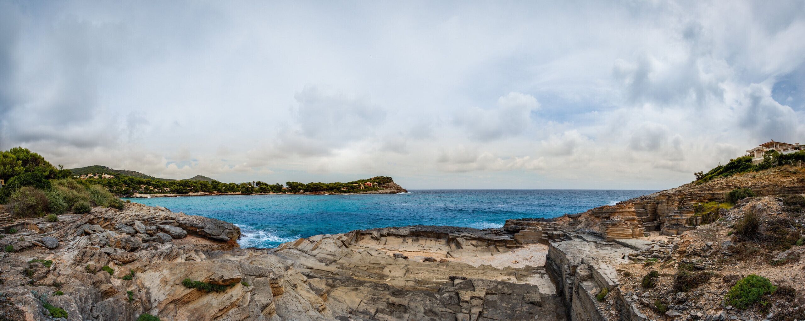 Un paysage côtier caractérisé par un terrain rocheux et une vue sur la mer.