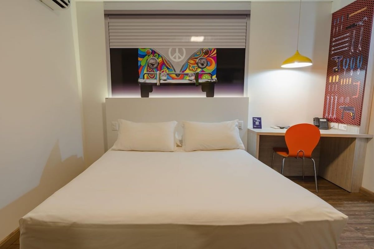 Une chambre à coucher avec un lit, un bureau et une chaise.