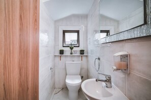 A compact bathroom with a toilet, sink, and a small window above the toilet. - SunnyVillas: 4BR Villa Private Pool+Jacuzzi+Sauna (Protaras)