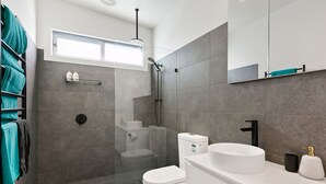 A modern bathroom with a shower, toilet, and sink. - Strathlea (Lorne)