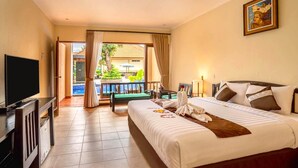 A hotel room with a bed, a TV, a balcony with a view of the outside, and a painting on the wall. - New Sunari Lovina Beach Resort (Buleleng)