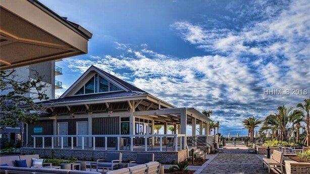 A hotel with a covered outdoor area, a stone pathway, and a view of the sky.